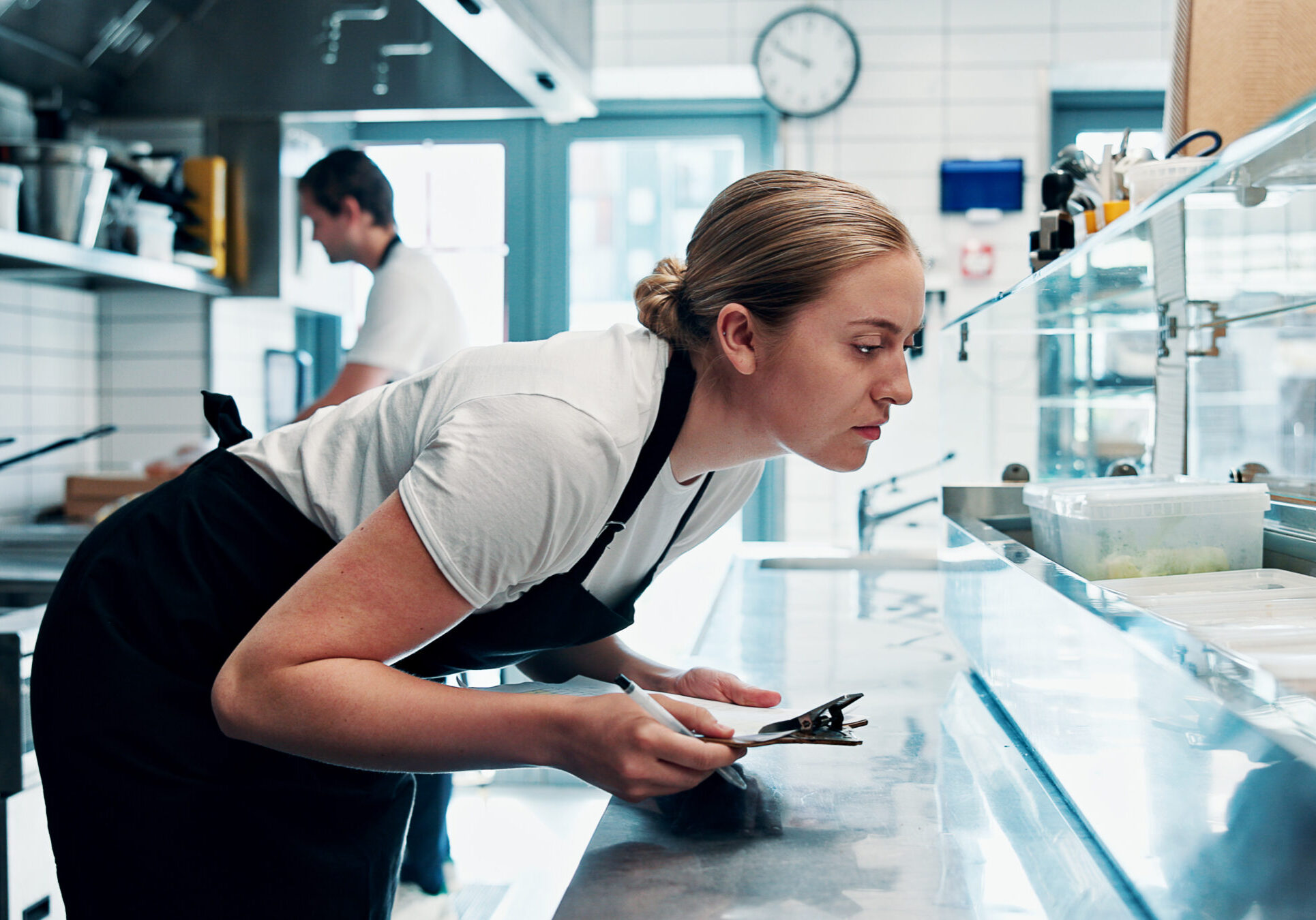 Chef, checklist or food inspection in kitchen for safety rules, hygiene or inventory management. Woman, clipboard or quality control in restaurant for hospitality compliance, regulations or feedback.